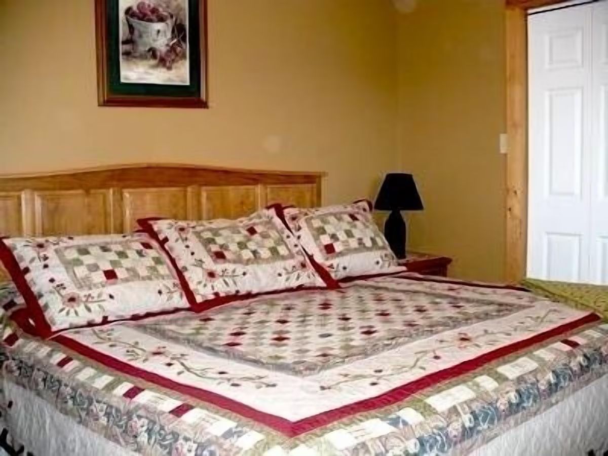 A bedroom with a king bed dressed for a restful night